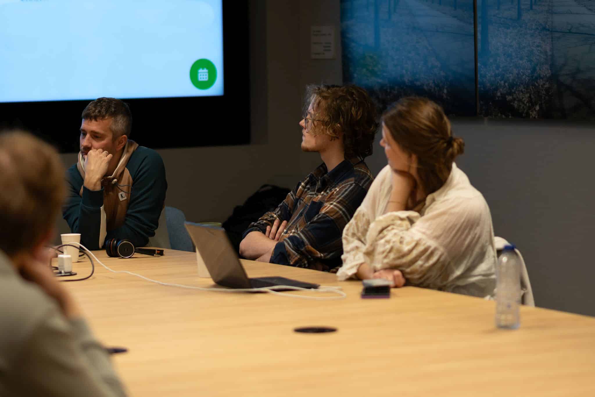 Foto van leden van het panel aan tafel aan het werk en luisteren